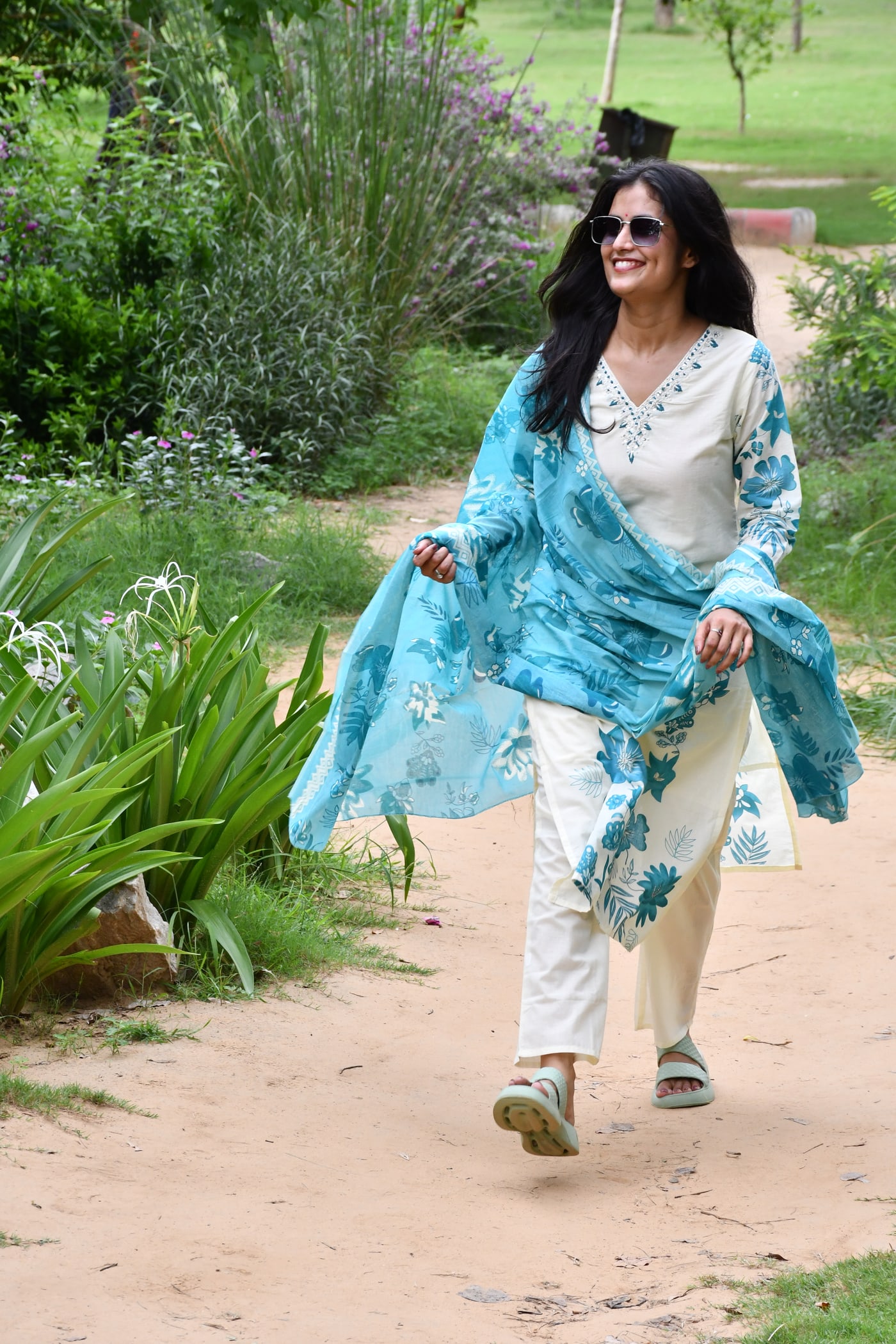 Ivory kurta with teal flowers, dupatta held out to one side