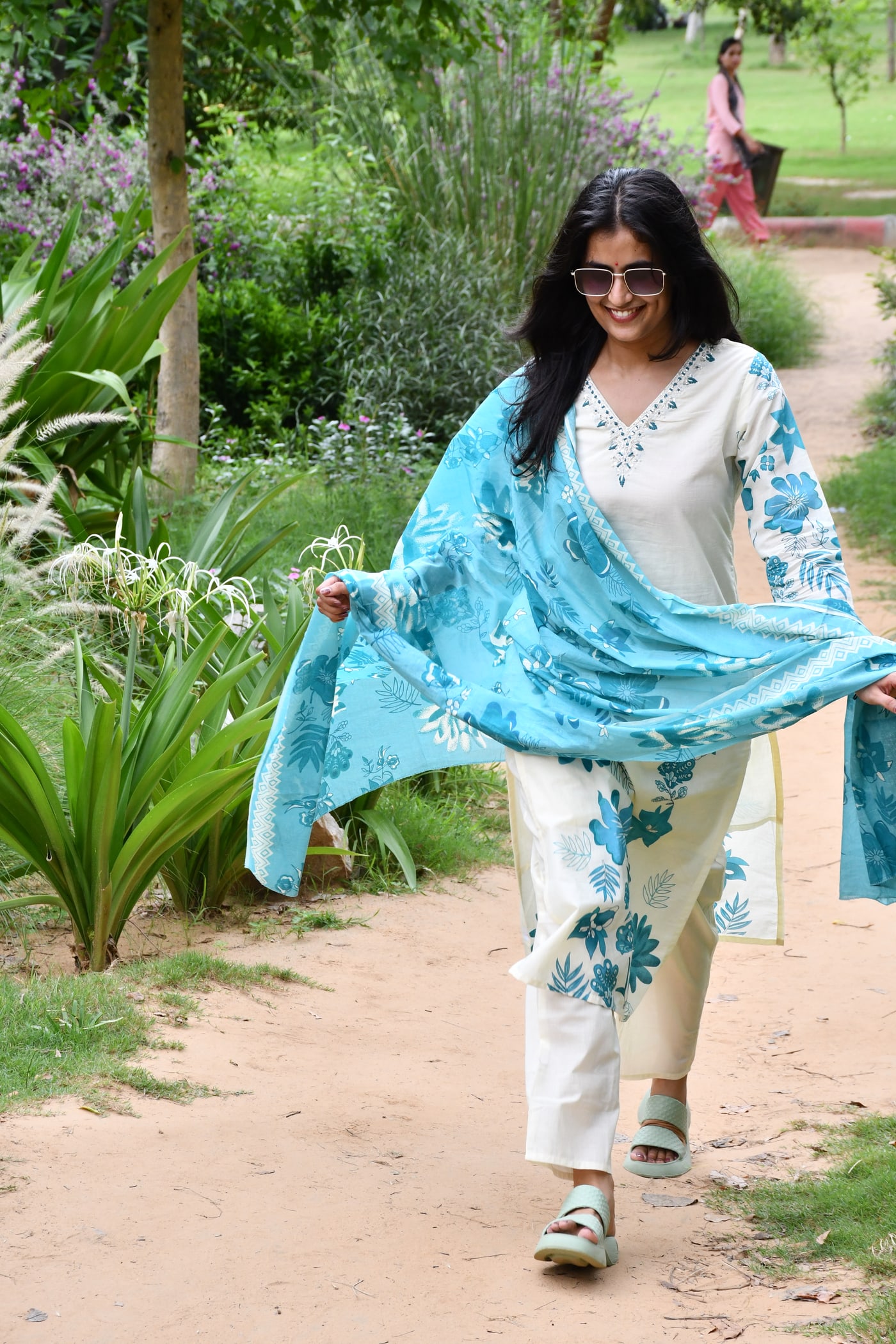 Ivory suit set worn on a garden path, dupatta open behind