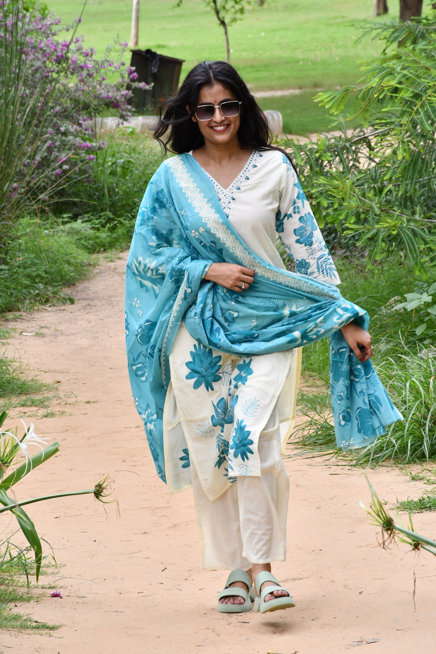 Ivory kurta and pant with the teal dupatta wrapped across the front