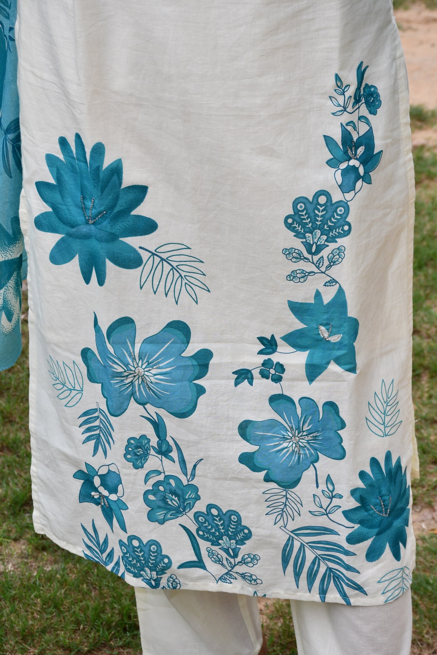 Ivory kurta hem, teal flowers printed over the ivory ground