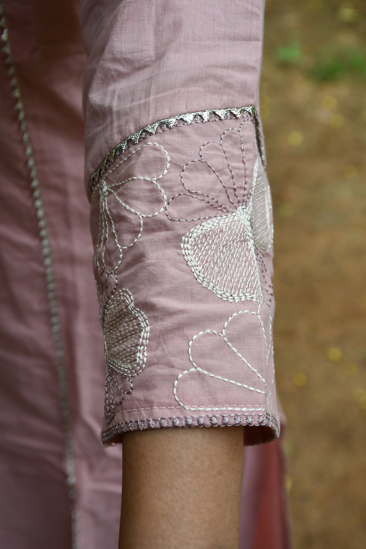 Dusty Rose sleeve cuff, white cutwork petals in detail